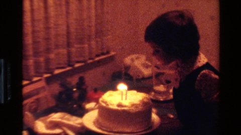 CALIFORNIA USA-1977: Three Year Old Girl Blowing Candles Off Cake On Her Birthday