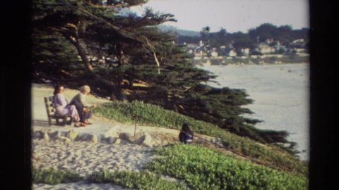 CARMEL CALIFORNIA USA-1982: People Standing On Beach Looking At Low Tide Surf On A Bright Sunny Day