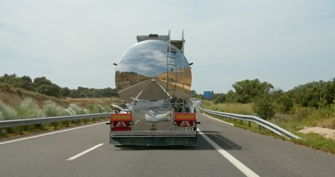 Rear view of trailer tanker truck or fuel tank transporting oil or gasoline to final destination. Concept earth pollution and logistics web in north america