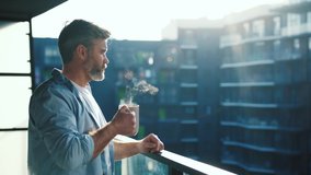 Handsome caucasian middle aged man stands in the balcony with great views and drinks hot coffee or tea, sun shine, enjoying beautiful morning feeling happy - Powered by Shutterstock - Get 15% off with code: PIKWIZARD15