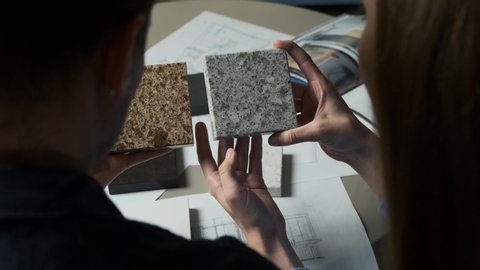 Man and woman choosing material samples close up. Team of architects discussing quartz materials for countertops in the kitchen. Artificial stone examples 4k