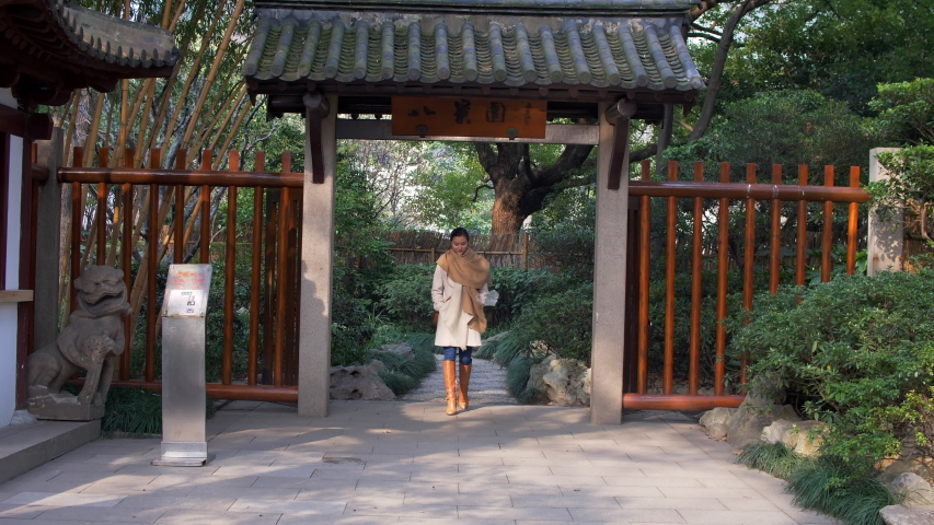 Attractive Young Mixed Woman Walks through the Chinese style Gates in Autumn 