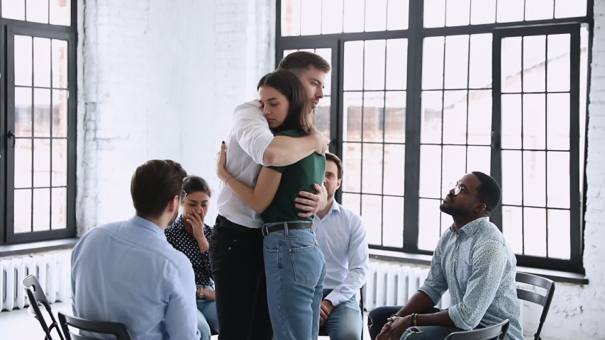 Male therapist embracing female patient giving support comforting helping with psychological problem during group therapy, hugging at rehab session as mental recovery, compassion and empathy concept | Shutterstock HD Video #1044846346