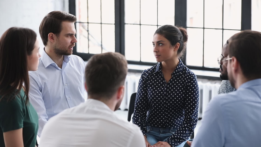Young confident professional indian female mentor leader counselor coach speaking at diverse business meeting with team people or patients group during training psychotherapy session sit in circle Royalty-Free Stock Footage #1044846367