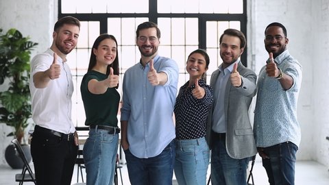 Happy proud professional diverse business people group show thumbs up look at camera stand in row in office, human resource recommend vote for best business choice concept, corporate team portrait