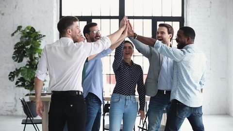 Happy diverse professional business office team give high five together in office, multiethnic coworkers group celebrate corporate success engaged in unity teamwork partnership concept, slow motion
