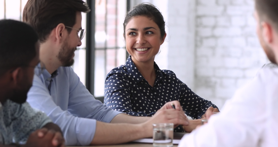 Smiling indian businesswoman hr team member executive talking to male job applicant coworker having professional friendly business discussion during employment interview, group meeting or negotiation Royalty-Free Stock Footage #1044846544