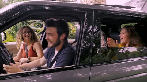 Two young couples in their late teens or early 20s getting into their SUV, buckling their seat belts, and are happy and excited for their journey - slow motion