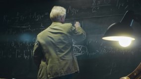 Elderly scientist or Professor is working or researching something late at night. University auditorium, table lamp shines. Anamorphic lens - Powered by Shutterstock - Get 15% off with code: PIKWIZARD15