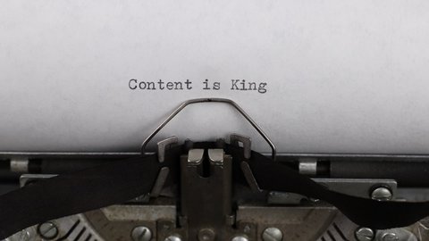 close-up typing a text content is king, old vintage typewriter with a sheet of paper 