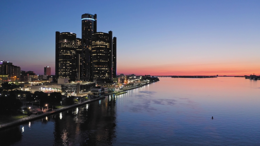 Aerial: Detroit city skyline and Detroit river at sunset. Detroit, Michigan, USA.