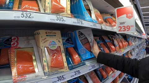 MOSCOW, RUSSIA - JANUARY 18, 2020: Woman choosing salted red fish in the supermarket.
