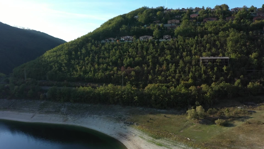 drone view on the top of green mountains, sea and village