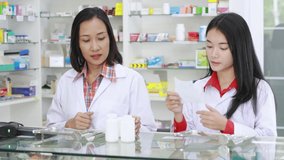 asian pharmacist checking and scanning barcode information medicine on computer in pharmacy store in Thailand footage video 4k