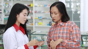 asian pharmacist woman talking medicine detail with patient in pharmacy store Thailand footage 4k video 