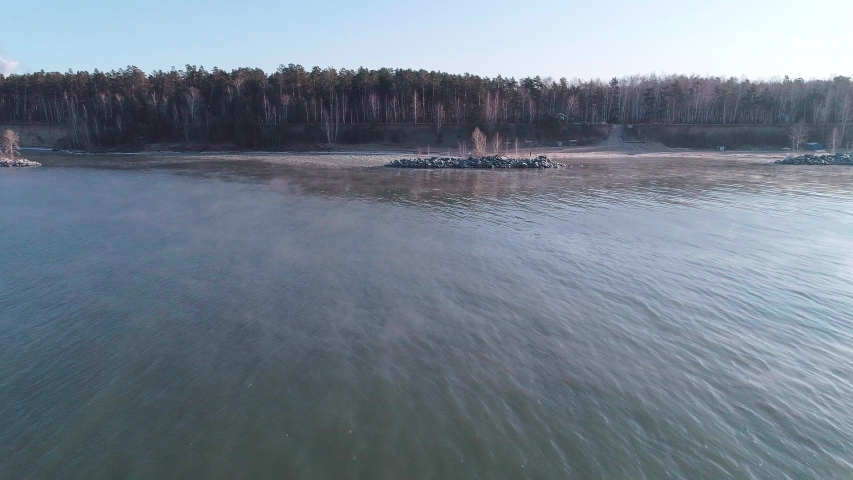 Sea sunrise and foggy morning. Fog above blue ripple water, aerial view.