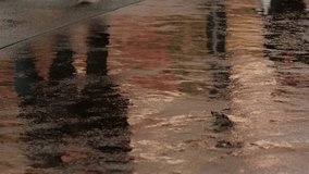 Prague, Czech Republic - September 2019: Reflections of people walking on wet pavement on a rainy day. 4K resolution. 