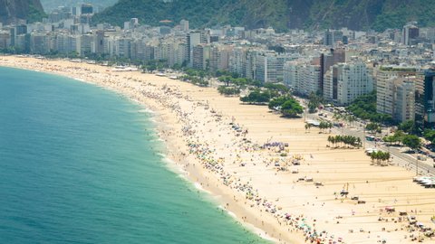 Aerial Timelapse of Copacabana beach in Rio de Janeiro, Brazil. View of the city skyline and buildings, the ocean, traffic and people.