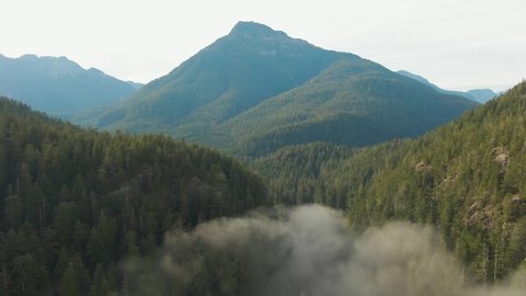 Aerial View of Beautiful Canadian Mountain Landscape above the clouds during a sunny day. Located on the West Coast of Vancouver Island near Tofino and Ucluelet, British Columbia, Canada.