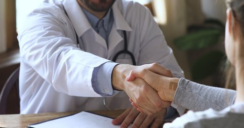 Male professional doctor practitioner wear white uniform consult handshake female patient agree on insurance contract at medical appointment in hospital, medicine healthcare concept, close up view