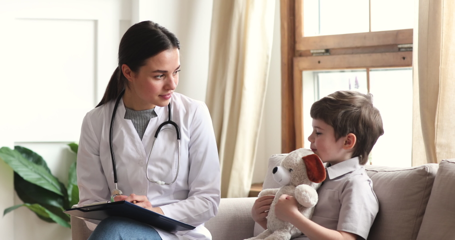 Caring professional female doctor nurse pediatrician talk to cute preschool child boy patient hold toy sit on sofa at medical consultation, children healthcare treatment pediatric checkup concept Royalty-Free Stock Footage #1044920824