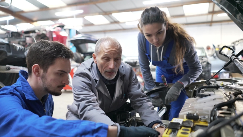 Instructor with trainees working on car engine  Royalty-Free Stock Footage #1044929491