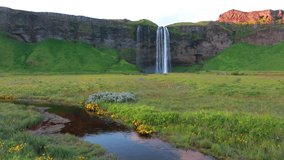 Summer view of Seljalandsfoss - where tourists can walk behind the falling waters. Amazing sunrise in Iceland, Europe. Beauty of nature concept background. Full HD video (High Definition).