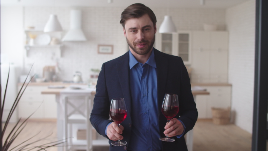 Closeup romantic couple celebrating success with wine at home. Successful family drinking alcohol at living room. Handsome man bringing glasses of wine to wife in slow motion. Royalty-Free Stock Footage #1044935341