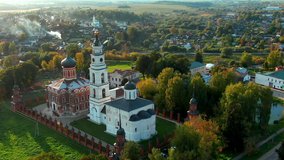 Volokolamsk Kremlin from a height at golden hour, beautiful nature in the background. Flies to the left around the Orthodox Church and the temple on the hill. Aerial video