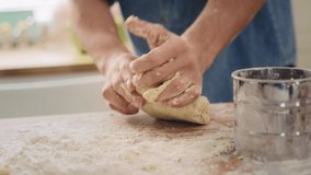 Handheld view of man’s hands kneading dough. Shot with RED helium camera in 8K
