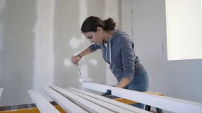 Apprentice in construction industry painting wood