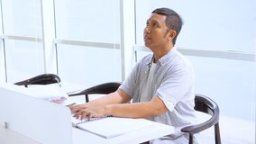 Blind Asian young man reading a braille book on the table while sitting in the library. Shot in 4k resolution - Powered by Shutterstock - Get 15% off with code: PIKWIZARD15