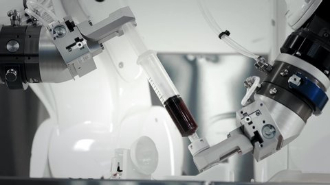 The innovative arms of a robotic arm make an injection of chemotherapy for a cancer patient. New technologies in medicine. Two manipulators draw medicine into a syringe. Hazardous substance injected