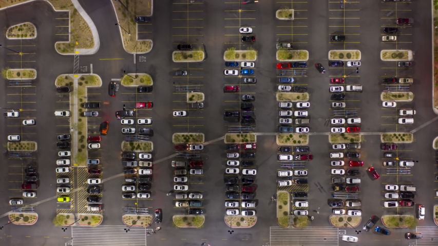 Aerial night timelapse of a busy grocery, shopping parking lot in suburban USA