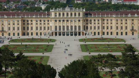 VIENNA AUSTRIA - JULY 11. 2019 wide and long master tripod shot of Schonbrunn / Schonbrunn Palace with baroque garden, people running around