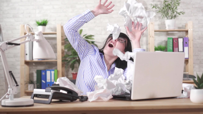 Concept of the idea over-worked,paper falling on a female office worker slow mo