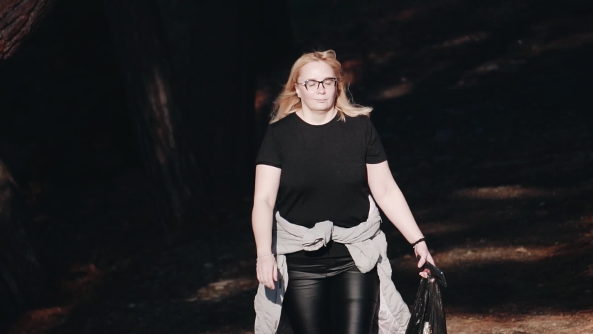 A girl walks through the Park. Her face is illuminated by the sun. Beautiful shots. Good weather.