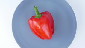 Red bell pepper spins on a plate. Food. Video.