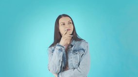 A young Thoughtful Woman in a Denim Jacket with her Arms Crossed is Thinking about something