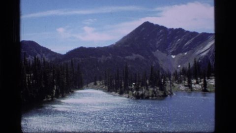 SAPPHIRE LAKE MONTANA USA-1977: Lake Waters Streaming South Away From Mountain Views Surrounded By Trees With Clear Skies