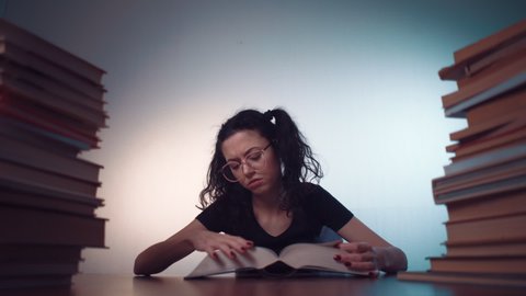 young girl bored of reading book and making homework