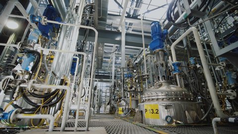 Refinery factory inside. Modern equipment, steel tanks and boilers with cables, pipelines and valves for chemical mixing. Production of anti-turbulent additives used in oil industry