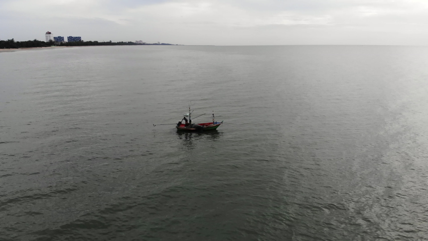 Panning view of a fishing boat during sunrise