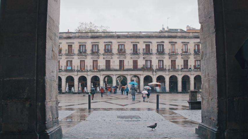 Plaza Nueva, Vitoria Gasteiz, people walking with umbrellas on a rainy day, town hall square, Basque Country