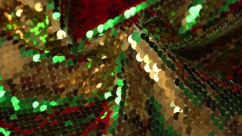 Gold, red, green paillette sequin fabric.   Shiny texture. Background for the holiday. Luxury glamorous fashion, textiles and accessories