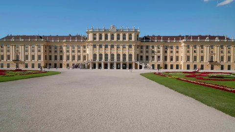 VIENNA AUSTRIA - JULY 11. 2019 Segway driving shot of Schönbrunn Palace / Schonbrunn Palace, moving left to right along baroque garden of Schönbrunn Palace, blue sky, people walking along, no sound
