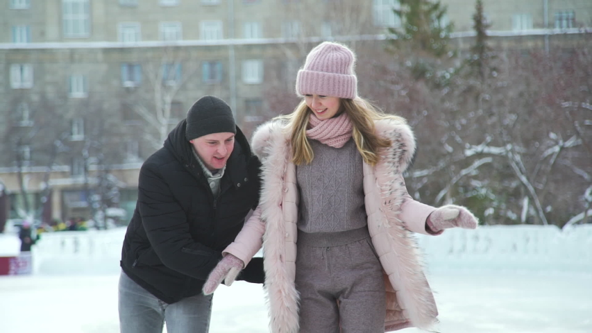 Close Up of Young Romantic Couple Skating on the Ice City Rink. Slow Motion. People, Winter, Friendship, Sport and Leisure Concept