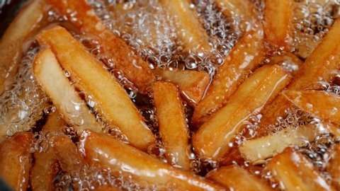 Slow motion of cooking french fries in the deep fryer, crispy fries, Junk food concept