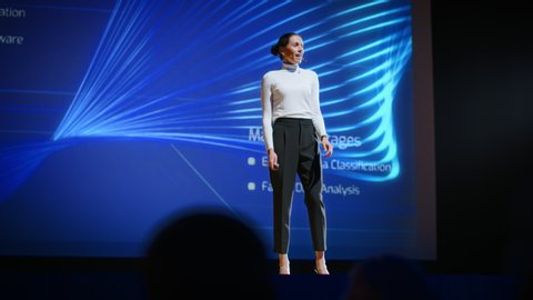 Successful Female Speaker Gets on Stage, Greets Audience and Does Presentation Technological Product, Shows Infographics, Statistics Animation on Screen. Live Event  Device Release  Start-up 