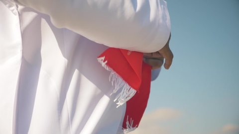 Omani man with Oman scarf flag , wearing  omani traditional dishdasha dress.